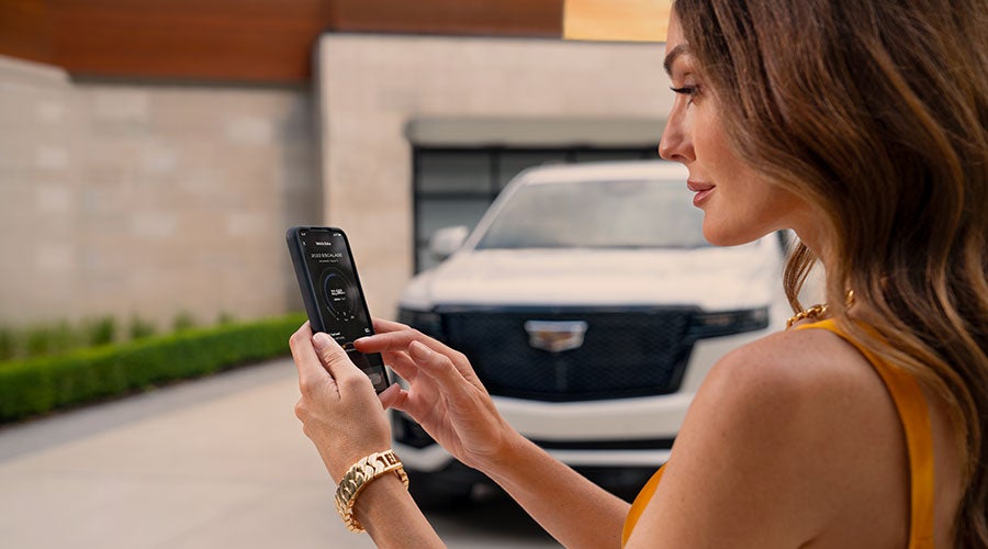 Woman using myCadillac mobile app on smartphone