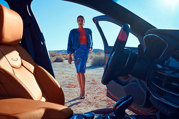 Woman walking toward Cadillac vehicle