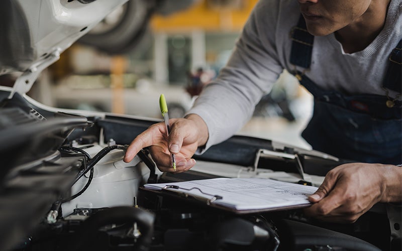 Technician inspecting vehicle engine